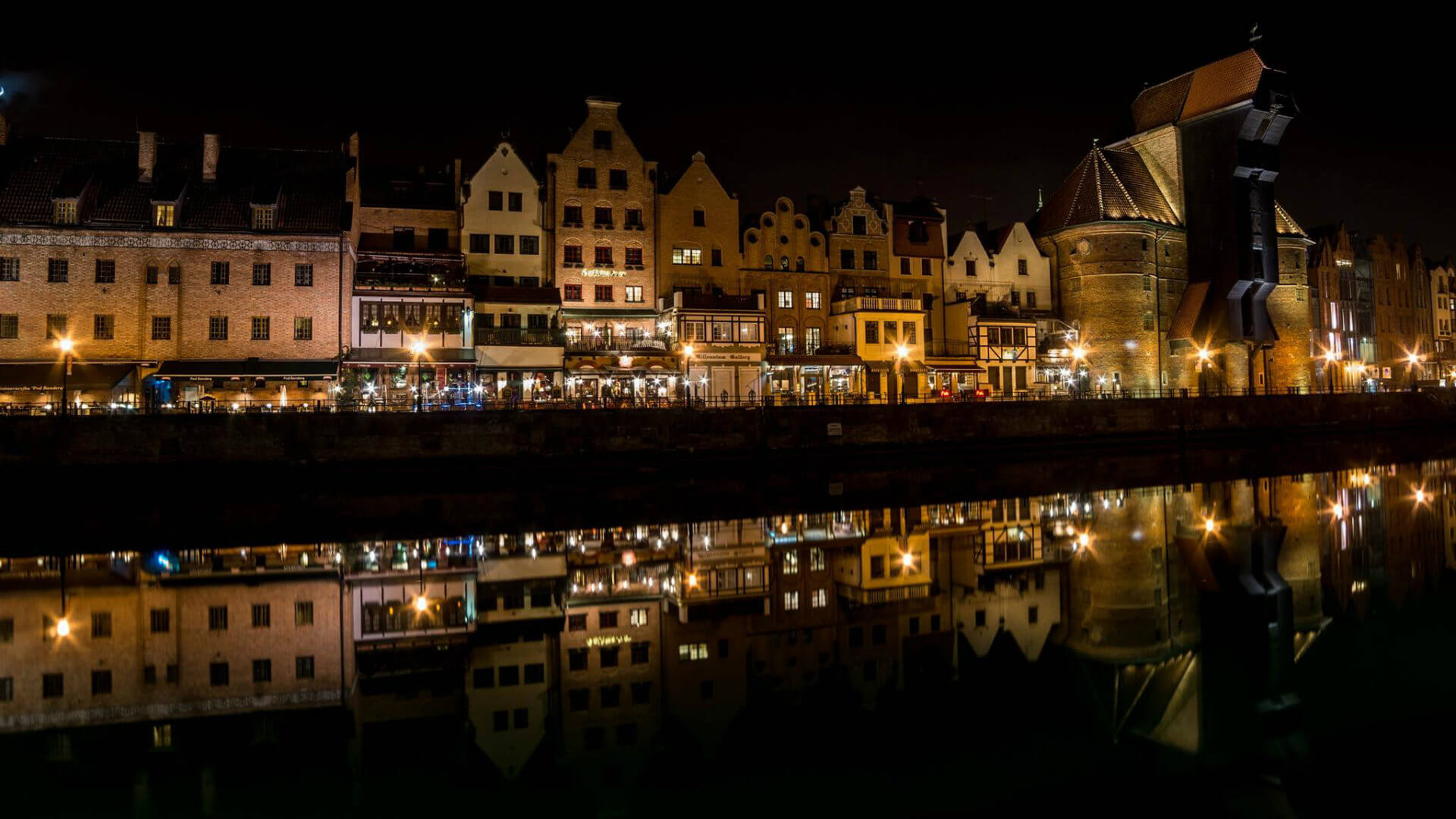 Gdańsk Old Town (Śródmieście), a view over the city depicting the merchants' houses. The Green Gate is visible at the left. Photograph taken by Sorin Lucian - View on Merchants houses and the crane from the other side of Motława river in Old Town by night.