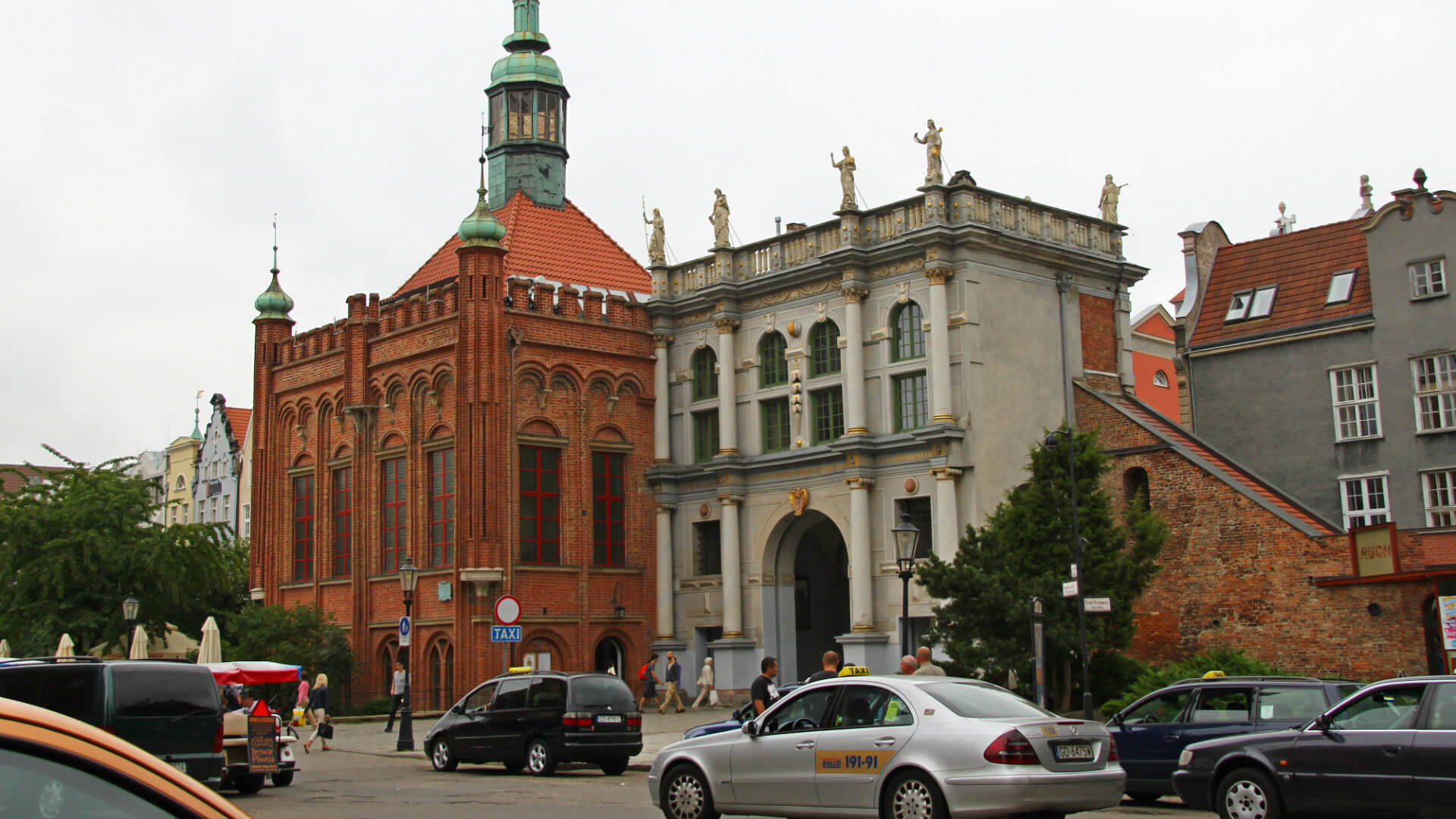 Taxi's/cabs waiting for passengers at the taxi station at the Golden Gate in Gdańsk Centre. Next to the Gate is the building of the Brotherhood of St.George. Taxi's/cabs waiting for passengers at the taxi station at the Golden Gate in Gdańsk Centre. Next to the Gate is the building of the Brotherhood of St.George.